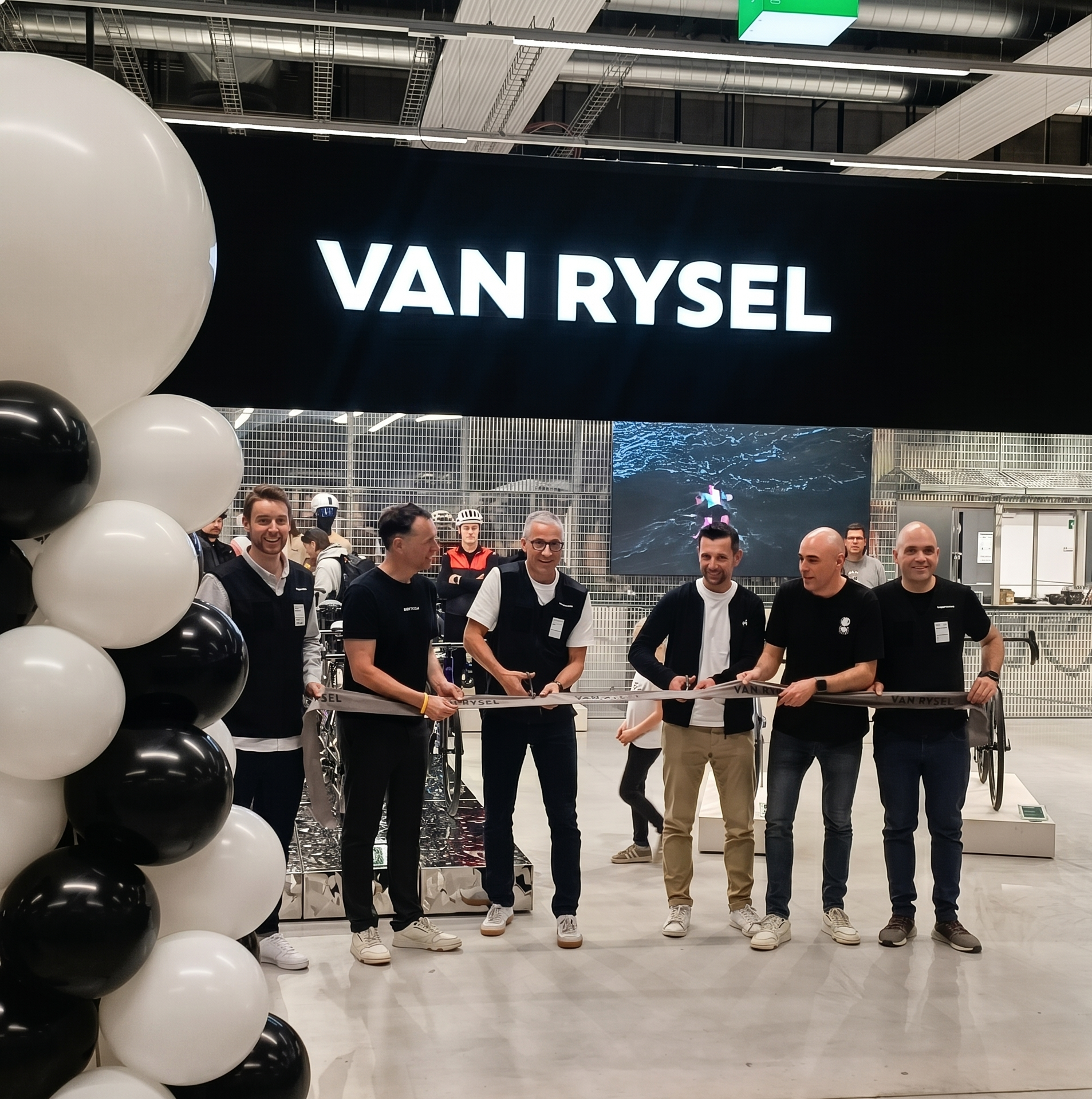 Seis hombres cortando la cinta inaugural de la tienda Van Rysel en Decathlon.