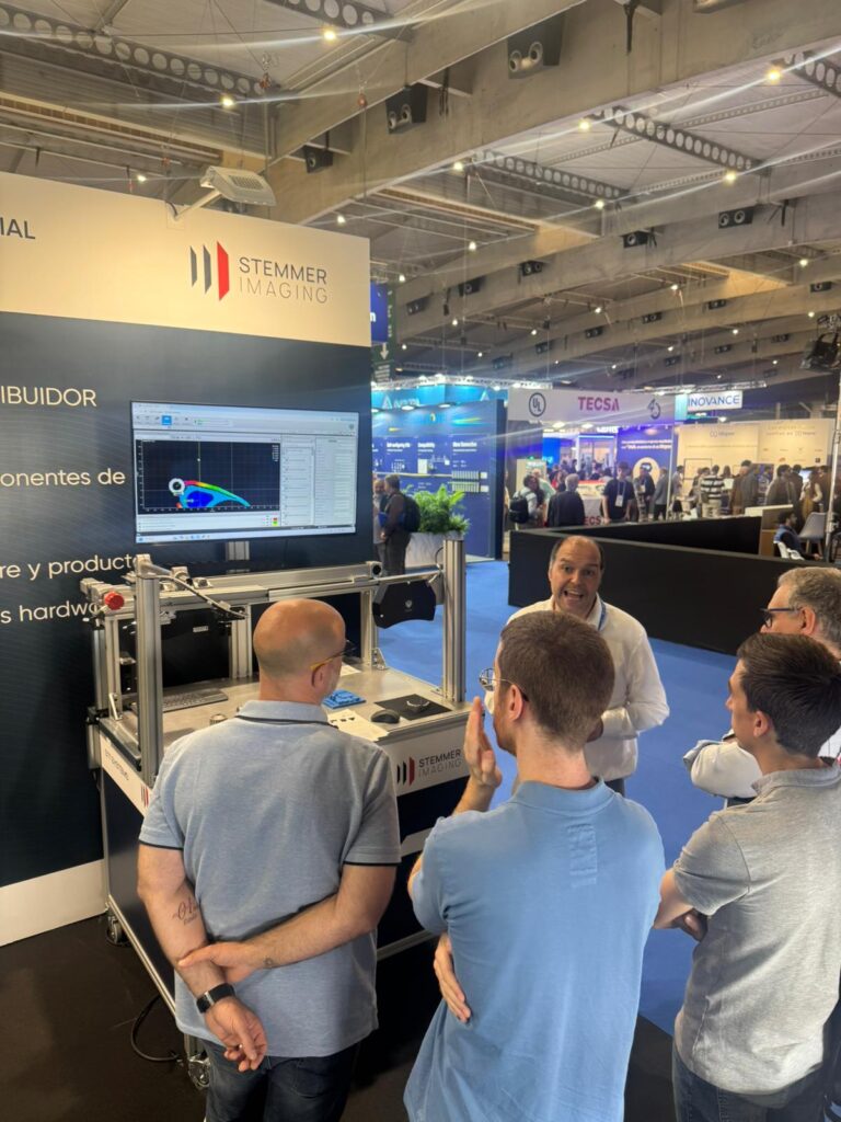 Jorge Molina de STT Systems explicando activamente el funcionamiento de una demo de inspección por visión artificial a un grupo de visitantes en la feria Advanced Factories.