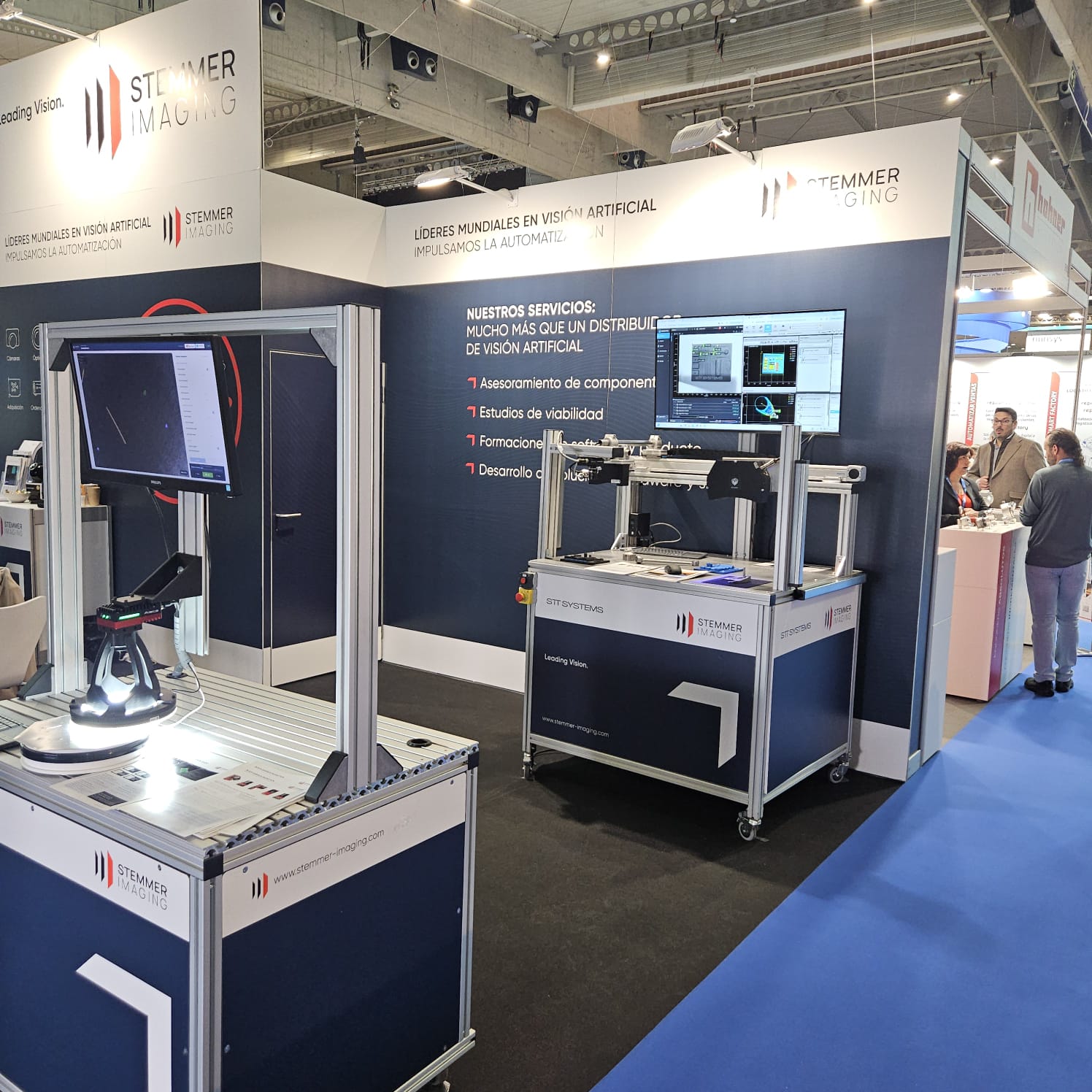 Muestra de dos estaciones de inspección por visión artificial diferentes en el stand de Advanced Factories, destacando una con iluminación anular intensa y otra con estación de trabajo completa.